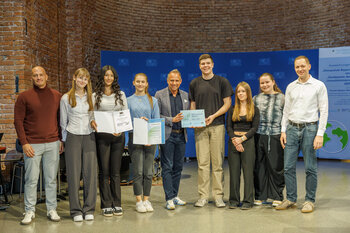 Sechs Schülerinnen und Schüler und zwei Lehrer der Fachoberschule und Berufsoberschule Aschaffenburg posieren mit Herrn Staatsminister Glauber und ihren Urkunden.